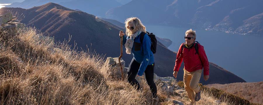 Retired couple hiking up mountain.